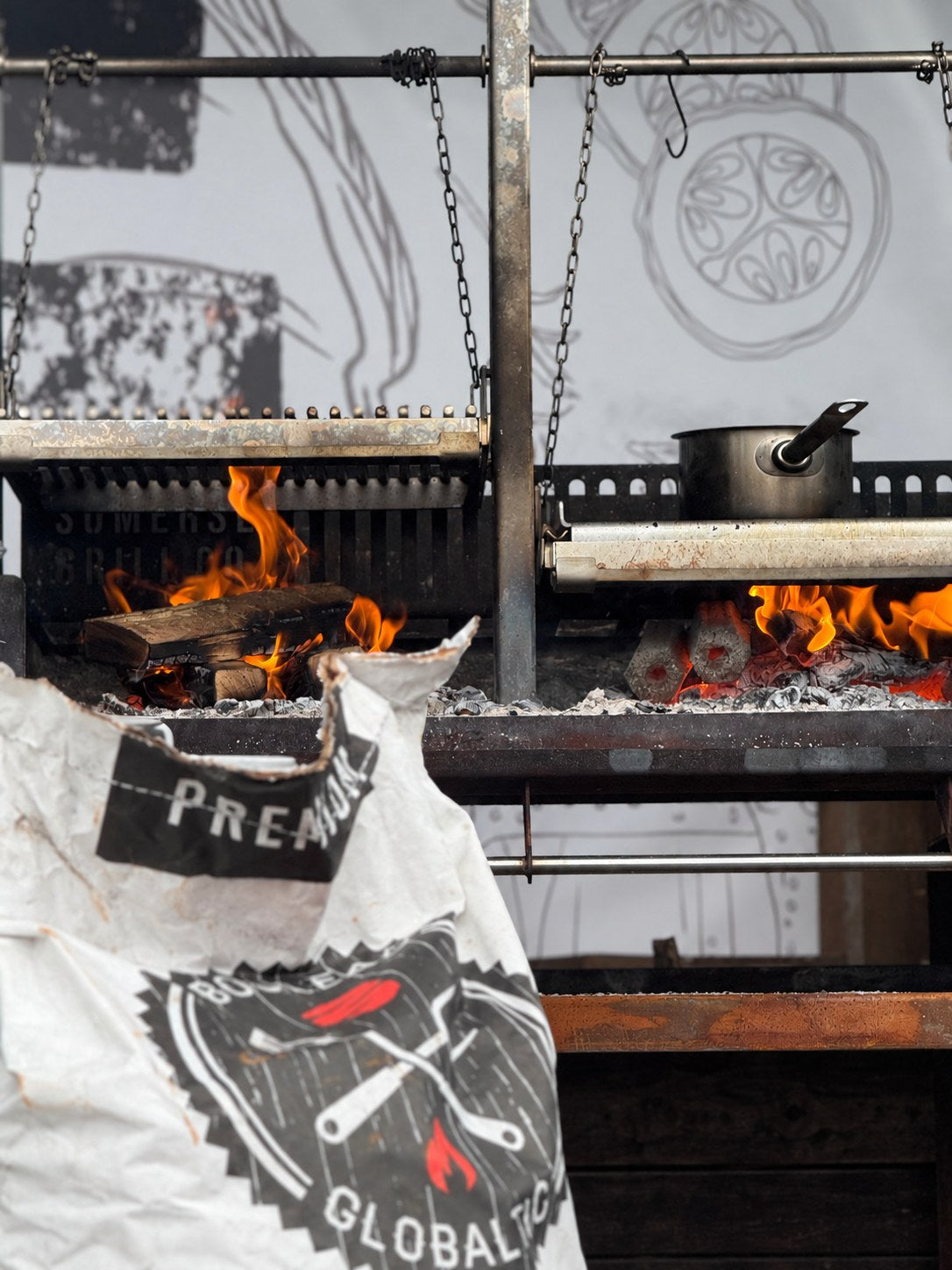 Hex briquettes and lumpwood burning together in a live-fire grill