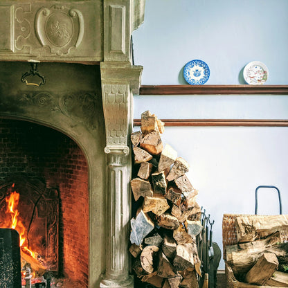 Real fireplace with stacked firewood — photo by Lucian Alexe on Unsplash